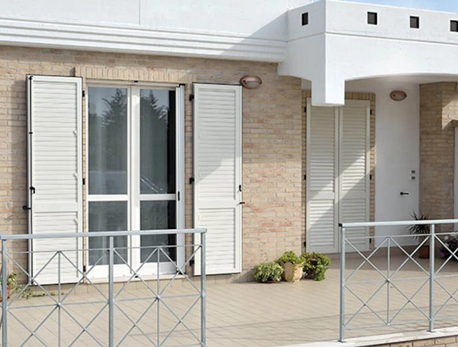 Persiane bianche per porte finestre viste dall’esterno in Emilia-Romagna